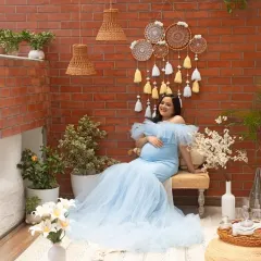 Our cozy corner setup, featuring a brick wall, dreamcatchers, and lush plants, provides a warm and intimate setting for this beautiful solo portrait in a light blue gown.