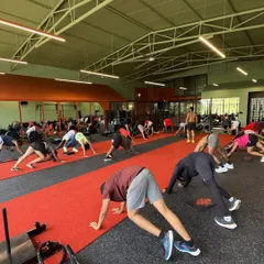A moment of synchronized stretching during a large group bootcamp. We focus on every aspect of fitness, including mobility and recovery, to ensure everyone trains safely and effectively.
