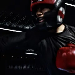 A female boxer throwing a straight right hand during a sparring session. Notice the focus and form, even in the heat of the moment.
