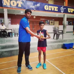 A junior boys' singles winner with his well-earned trophy. These events are designed to build match temperament and experience for young athletes.