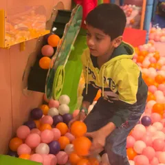 Having a blast in the giant ball pit. This area includes interactive elements like this ball conveyor, adding an extra layer of fun to the experience.