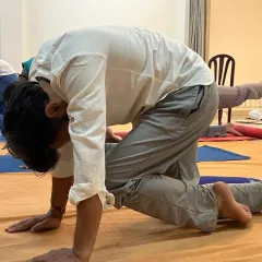 A participant deeply involved in a posture during a Surya Kriya class. The practice demands a certain level of involvement to reap its full benefits.