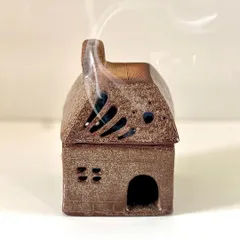 A finished house incense burner, with the smoke curling out of the chimney. The textured roof and tiny windows give it so much character.
