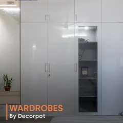 A sleek, all-white hinged wardrobe with a high-gloss finish that brightens the room. The design includes an integrated open shelving unit, perfect for displaying decor or keeping frequently used items handy.
