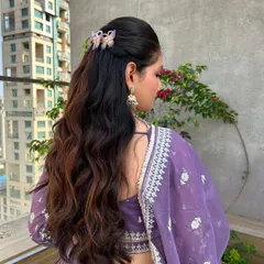 A closer look at the half-up style, accented with whimsical butterfly clips that add a touch of modern fun to the classic wavy look.