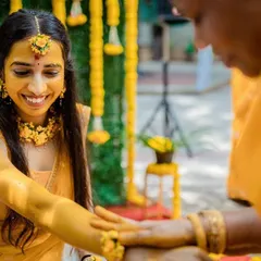 A quiet, beautiful moment during the Haldi rituals. A family member applies turmeric paste, and we capture the bride's serene and happy smile.