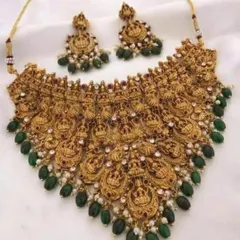A magnificent temple jewellery choker necklace with green bead drops. The design features repeating goddess Lakshmi motifs, making it a very auspicious and traditional choice for a bride.