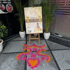 A beautiful entrance for a haldi ceremony, featuring a custom welcome sign and a flower petal rangoli on the floor.