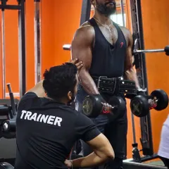 During a bicep curl, I am making a minor adjustment to my client's form. Small corrections like this are what prevent injury and ensure the right muscles are doing the work, leading to real, sustainable strength gains.