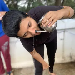 A female student performs Jal Neti with a steel pot. We ensure all our students learn these traditional techniques safely and effectively.