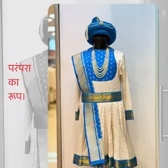 "Parampara ka roop." This blue and ivory Peshwai outfit captures the essence of tradition. The matching blue turban, belt, and shawl create a coordinated and regal look.