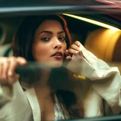 A beautiful and serene portrait through the glass. Her expression is calm and engaging, creating an intimate connection despite the physical barrier of the window.