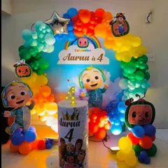 A vibrant Cocomelon theme for a 4th birthday party. This setup is packed with color, featuring a rainbow balloon arch, multiple character cutouts, and a custom pedestal for the cake.