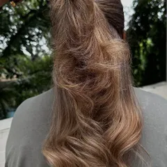 Holding up a section to show the intricate highlights and the health of the hair, even after lightening.