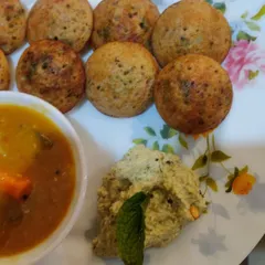 A full plate of freshly made appe, also known as puddu or paniyaram, served with a side of vegetable sambar and coconut chutney.