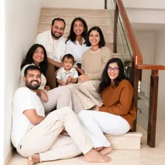 An extended family portrait taken at home on the stairs. At-home sessions are perfect for capturing multiple generations together in a place full of memories.