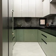 This kitchen strikes the perfect balance between earthy charm and modern edge. Olive green base cabinets bring a grounded, organic warmth, while soft grey overhead units and a bold black quartz countertop anchor the space with drama and depth.