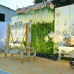 An angled view of the barsa ceremony stage, highlighting the layers of decoration. You can see the hanging floral arrangements, the textured backdrop, and the elegant side tables with elephant statues.