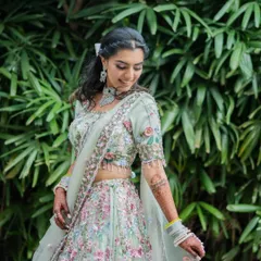 A stunning portrait of the bride-to-be on her engagement day. The soft natural light beautifully highlights the intricate floral details of her pastel lehenga and her happy glow.