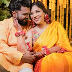 A radiant Haldi look for this bride. Her makeup is kept fresh and glowing to complement the vibrant yellow and orange saree and floral jewelry.