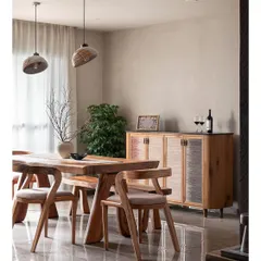 This dining room showcases a Wabi-Sabi aesthetic with its limewash wall and banana fibre-finished crockery console. The custom live-edge dining table and chairs bring an organic, natural feel to the space.