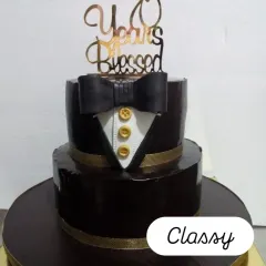 A sophisticated two-tiered tuxedo cake for a 70th birthday. The rich chocolate ganache finish and gold button details add a touch of class.