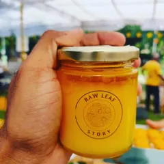 A jar of our pure, raw honey, held up at one of our market stalls. It's a natural sweetener, full of goodness, and a healthy addition to your daily diet.