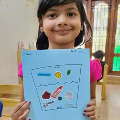A proud student shows her worksheet where she has correctly sorted objects that float and sink. This reinforces the concepts learned during our science experiment.