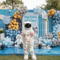 An astronaut mascot poses in front of a cosmic backdrop at a space-themed birthday party. This interactive element adds a layer of fun and makes for fantastic photo opportunities for the kids.