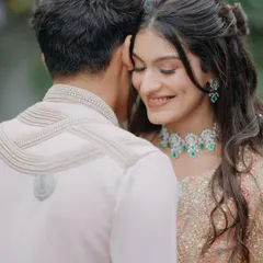 A tender moment during a Haldi ceremony. The bride's joyful, closed-eyed smile as she leans into her partner captures the pure happiness and intimacy of the pre-wedding rituals.