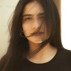 A close-up portrait where a bit of wind adds natural movement to the hair. This creates a candid, unposed feeling that brings the image to life.