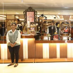 Our skilled culinary artisans take pride in crafting flavours that delight the senses. A member of our service team stands ready at an elegant buffet station.