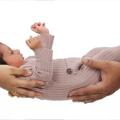 There's nothing like the feeling of holding your new baby. This classic pose highlights the connection and love of new parents, creating a timeless family portrait that focuses on their hands supporting their little one.