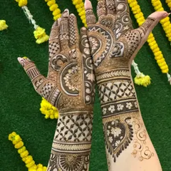 A complete bridal mehandi look, with full coverage on both hands and forearms. The design uses a mix of floral, paisley, and geometric patterns for a classic bridal style.