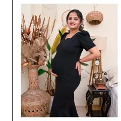 A confident and happy portrait of a mom-to-be in our Boho-themed studio. The black dress creates a lovely contrast with the natural textures of the wicker, dried plants, and vintage-style telephone.