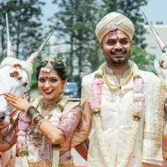 A joyful moment from a wedding procession. The groom's custom silk couture and the bride's matching ensemble shine even in the bright daylight.
