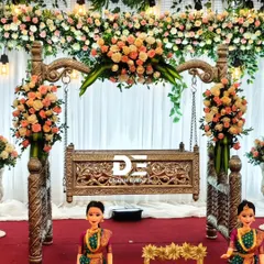 For a timeless naming ceremony, I designed this elegant floral cradle setup. The beautifully carved wooden cradle is adorned with fresh peach and white roses, creating a serene and classic centerpiece for the special day.