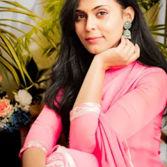 A warm, intimate portrait in a pink ethnic outfit. The soft lighting and close-up framing create a personal and engaging feel.