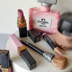 A detailed close-up of the Chanel-themed makeup cake. I spent hours sculpting the tiny lipstick, perfume bottle, and makeup brushes to make them look as realistic as possible, all completely edible.