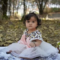 A baby girl's outdoor milestone session, complete with a curious cat who decided to join the photo. A truly unique and candid moment.