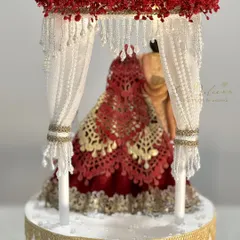 A close-up of the handcrafted Mandap cake topper. We used edible lace for the bride's lehenga and delicate sugar pearls for the curtains to create a realistic and beautiful effect.