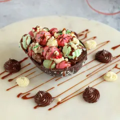 Celebrate Easter in style with our delicious chocolate eggs. This one is a chocolate shell filled with colorful mini macarons and meringues, drizzled with more chocolate.