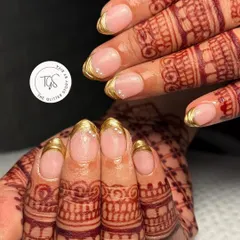 Simple, elegant, and perfect for a bride. These classic gold chrome tips on beautifully shaped nails are a timeless choice that looks stunning with traditional henna.