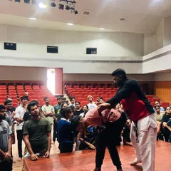 We believe in empowering our community with practical skills. Here, our coach demonstrates a self-defense technique to an engaged audience during a workshop at the National Institute of Fashion Technology (NIFT).
