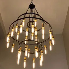 Lighting can define a workspace. This stunning two-tiered chandelier with Edison bulbs serves as a focal point in a corporate lobby, providing both ample light and a dose of modern industrial style.