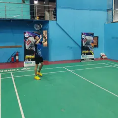 **Perfecting the Serve.** A player practicing his serve with one of the new Yonex rackets, focusing on precision and technique.