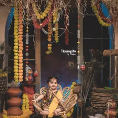 *Nanhi si Radha, muskaan mein pyaar chhupa.* This little girl looks absolutely divine as Radha in our rustic Janmashtami setup, complete with a peacock chair and marigold garlands.