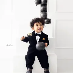 A little gentleman celebrating his first birthday in style! This dapper tuxedo and minimalist set create a chic and modern milestone portrait.