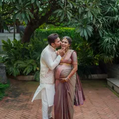 A candid, affectionate moment between partners during their outdoor maternity photoshoot. These are the sweet, unscripted memories that tell the real story of your love.