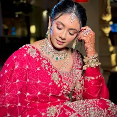 A close-up of a bride with a classic floral bun. The hairstyle is neat and polished, allowing the focus to remain on her beautiful makeup and jewellery.
